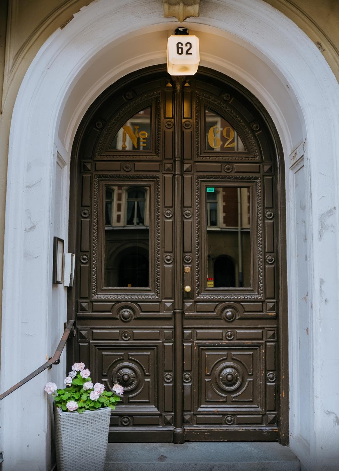 Porte en bois sculptée sous une arcade blanche