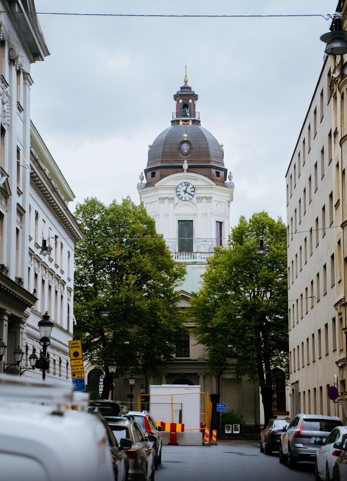 Rue bordée d'immeubles menant à une église à coupole