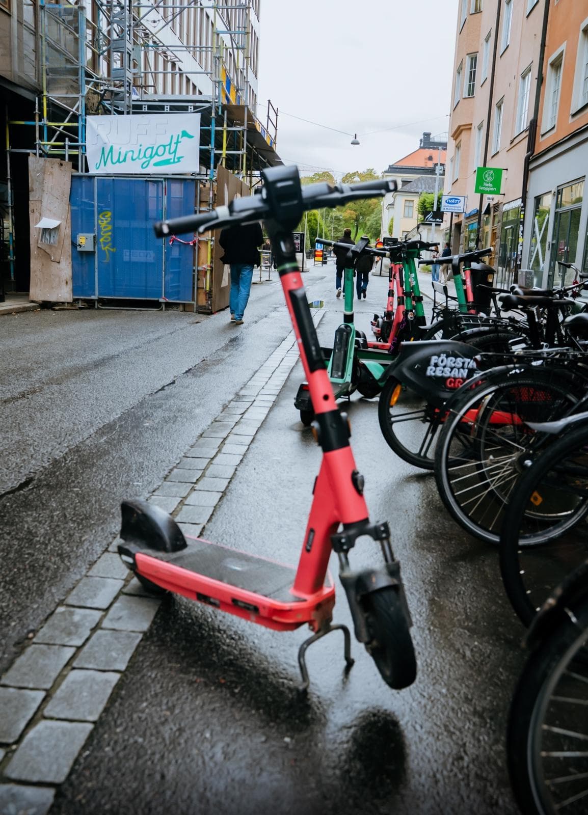 Trottinettes et vélos sur un trottoir mouillé