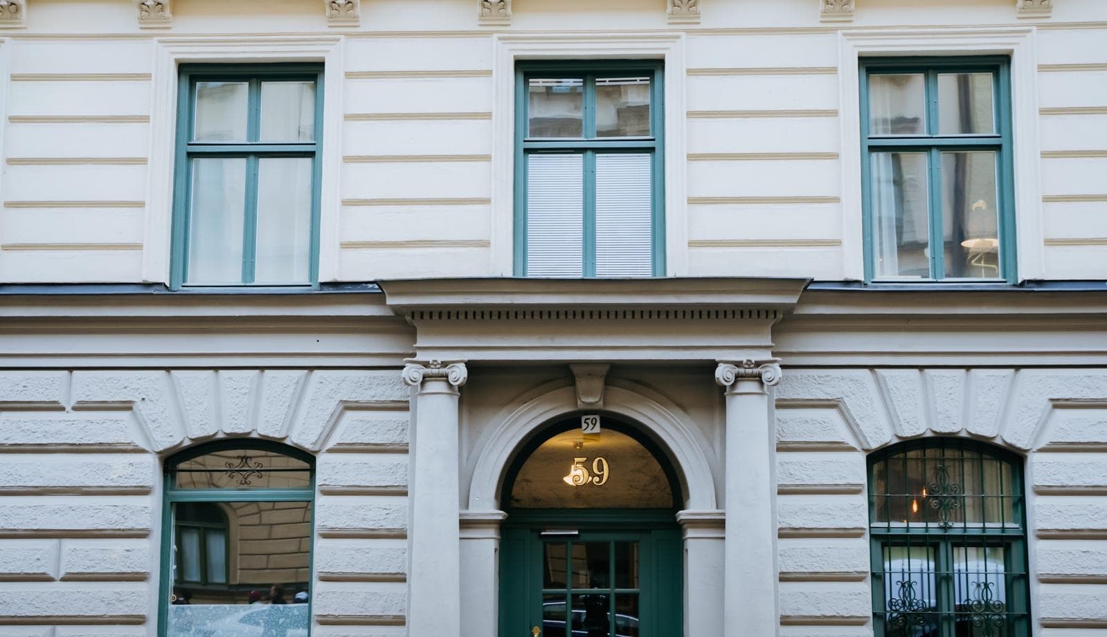 Façade claire aux fenêtres vertes